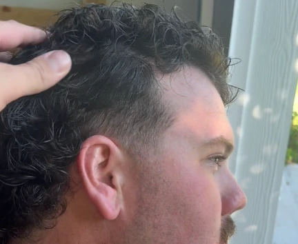 Close-up of a sharp temple taper paired with dark curls
